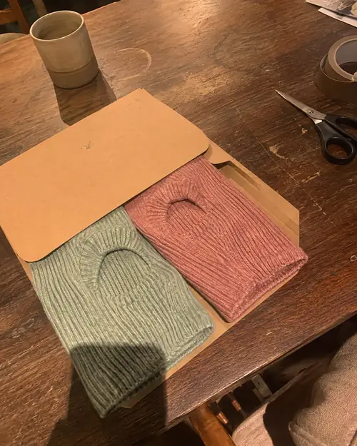 Two finished handmade dog garments packed to ship